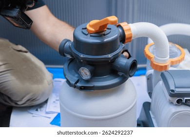 Plumber is installing pool filter system, checking connections gauges in backyard environment.