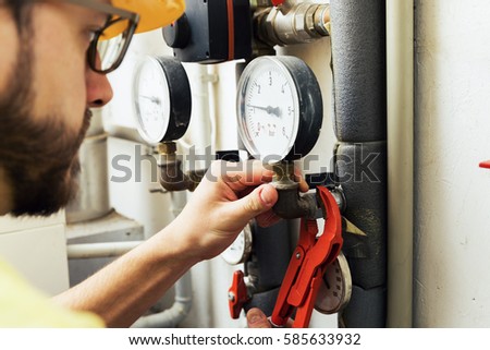 plumber installing pressure meter for house heating system