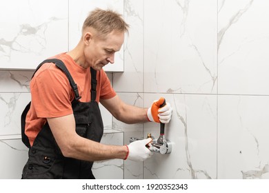 The Plumber Is Installing A Shower Faucet With An Adjustable Wrench.