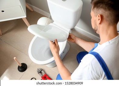 Plumber installing toilet in restroom - Shutterstock ID 1528034909