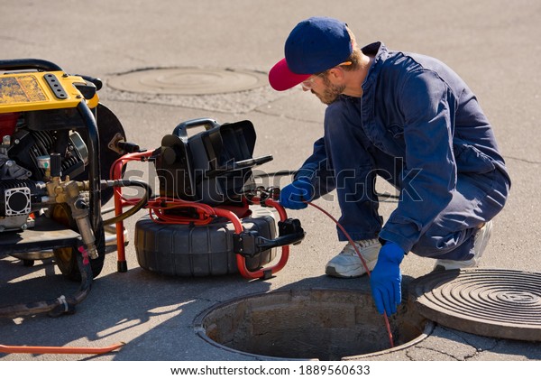 Plumber prepares\
to fix the problem in the sewer with portable camera for pipe\
inspection and other plumbing\
work.