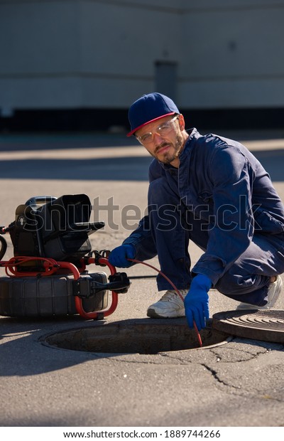 Plumber prepares\
to fix the problem in the sewer with portable camera for pipe\
inspection and other plumbing\
work.