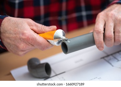 Plumber Putting Glue On A Pvc Pipe