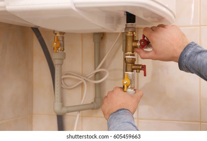 Plumber Repairing Boiler In Bathroom