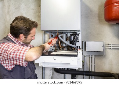 Plumber Repairing A Condensing Boiler