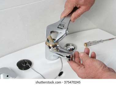 Plumber Repairing The Faucet Of A Sink.
