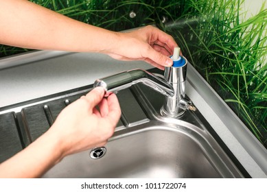 Plumber Repairing The Faucet Of A Sink In Kitchen, Man Repair And Fixing Leaky Old Faucet, Cartridge Or Mixer Of The Faucet, Concept Of Repair And Technical Assistance