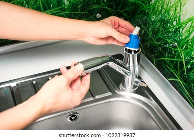 Plumber Repairing The Faucet Of A Sink In Kitchen, Man Repair And Fixing Leaky Old Faucet, Cartridge Or Mixer Of The Faucet, Concept Of Repair And Technical Assistance