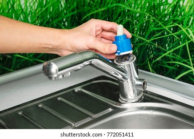 Plumber Repairing The Faucet Of A Sink In Kitchen, Man Repair And Fixing Leaky Old Faucet, Cartridge Or Mixer Of The Faucet, Concept Of Repair And Technical Assistance