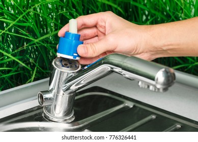 Plumber Repairing The Faucet Of A Sink In Kitchen, Man Repair And Fixing Leaky Old Faucet, Cartridge Or Mixer Of The Faucet, Concept Of Repair And Technical Assistance