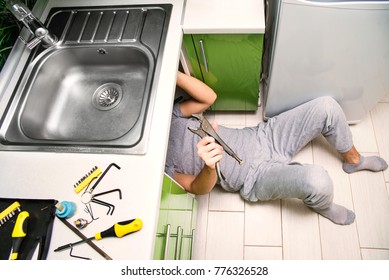 Plumber Repairing The Faucet Of A Sink In Kitchen, Man Repair And Fixing Leaky Old Faucet, Cartridge Or Mixer Of The Faucet, Concept Of Repair And Technical Assistance, Top View, Kitchen Overview