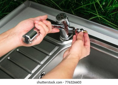 Plumber Repairing The Faucet Of A Sink In Kitchen, Man Repair And Fixing Leaky Old Faucet, Cartridge Or Mixer Of The Faucet, Concept Of Repair And Technical Assistance