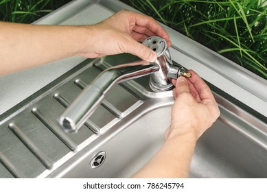 Plumber Repairing The Faucet Of A Sink In Kitchen, Man Repair And Fixing Leaky Old Faucet, Cartridge Or Mixer Of The Faucet, Concept Of Repair And Technical Assistance