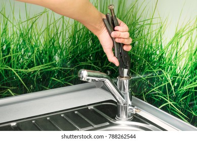 Plumber Repairing The Faucet Of A Sink In Kitchen, Man Repair And Fixing Leaky Old Faucet, Cartridge Or Mixer Of The Faucet, Concept Of Repair And Technical Assistance