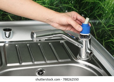 Plumber Repairing The Faucet Of A Sink In Kitchen, Man Repair And Fixing Leaky Old Faucet, Cartridge Or Mixer Of The Faucet, Concept Of Repair And Technical Assistance