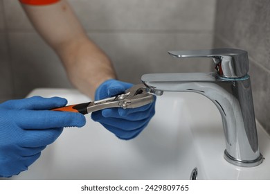 Plumber repairing faucet with spanner in bathroom, closeup - Powered by Shutterstock