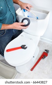 Plumber Repairing A Flush Toilet