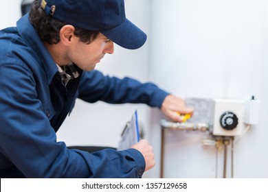 Plumber repairing an hot-water heater - Shutterstock ID 1357129658
