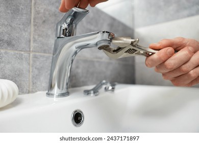 Plumber repairing metal faucet with spanner in bathroom, closeup - Powered by Shutterstock