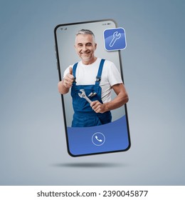 Plumber and repairman videocalling on smartphone and giving a thumbs up, hire a contractor online - Powered by Shutterstock