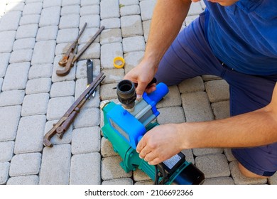 A Plumber Repairs A Water Pump With Wrenches. Damaged Electronics In The Pump. Performs Repair And Installation Of Water Supply Systems.