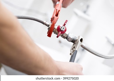 plumber screwing plumbing fittings in bathroom