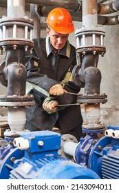 Plumber Technician Works With Water Pump In Central Heating Room