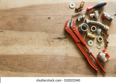 Plumber  Tools And Fittings On Wooden Background