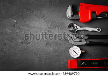 Plumber tools on concrete structure background