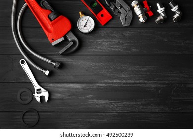 Plumber Tools On A Gray Wooden Background