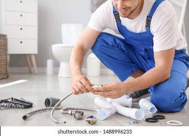 Plumber with tools working in restroom - Shutterstock ID 1488996233