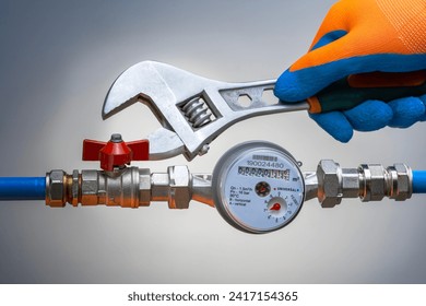 plumber using a wrench to repair a water pipe. . handyman service. small business. water meter replacement.