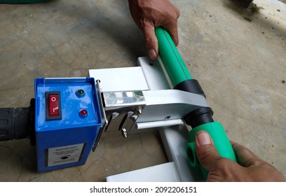 Plumber weld procces two pieces of green PPR pipe.Industrial plumber  hot water type  connection.
