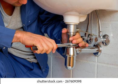 a plumber  at work in a bathroom - Shutterstock ID 267609398