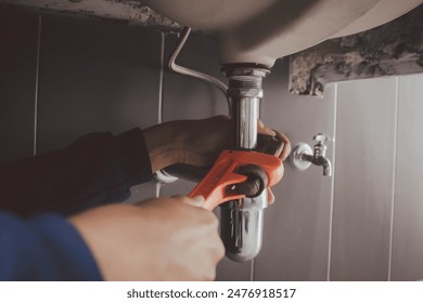 plumber at work in a bathroom, plumbing repair service , fix water plumbing leaks, replace the kitchen sink drain - Powered by Shutterstock