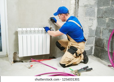 plumber at work. Installing water heating radiator