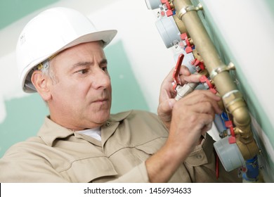 Plumber At Work Installing A Water Meter