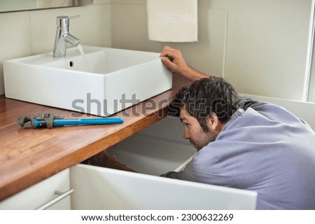 Plumber working under kitchen sink
