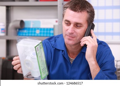 Plumbers merchant on the phone with a part in hand