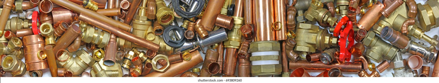 Plumber's pipes , fittings and wrenches  website banner  –  wide  random mixture of copper pipe, brass fittings  and wrenches ideal for use as a website header  background