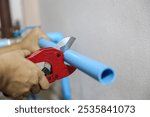 Plumbers are using pipe cutters to cut pvc pipes to repair water are leaking, dripping, or installing water pump connections in the home.