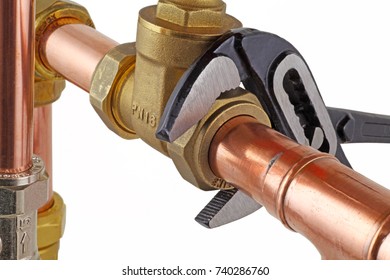 Plumber's wrench tightening up a valve – An adjustable wrench tightening up a compression joint isolated on a white  background