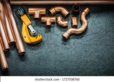 Plumbing Concept Copper Pipes Pipe Cutter And Fittings On Black Background