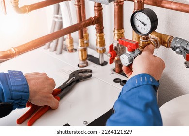 Plumbing concept or service water worker. copper pipeline of a heating system in technical room. Boiler and expansion expansion tank system, detail of pressure gauge. - Shutterstock ID 2264121529