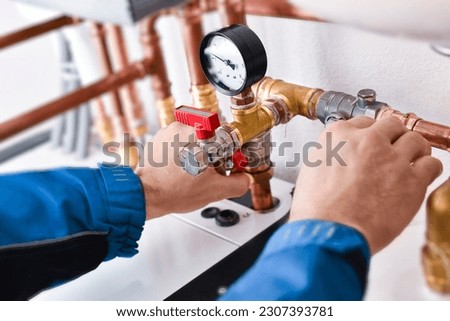 Plumbing concept or service water worker. copper pipeline of a heating system in technical room. Boiler and expansion expansion tank system, detail of pressure gauge.