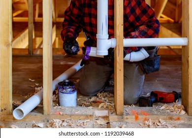 Plumbing Contractor Installing Plastic PVC Pipe In Under The Bathroom Sink