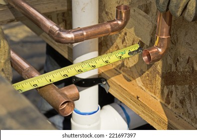 Plumbing contractor works on the copper pipe domestic water system on a luxury custom home