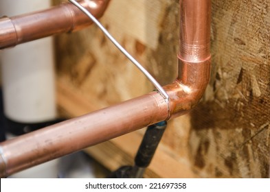 Plumbing Contractor Works Sweating The Joints On The Copper Pipe Domestic Water System On A Luxury Custom Home