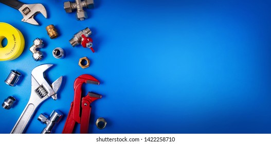 plumbing tools and fittings on blue background with copy space