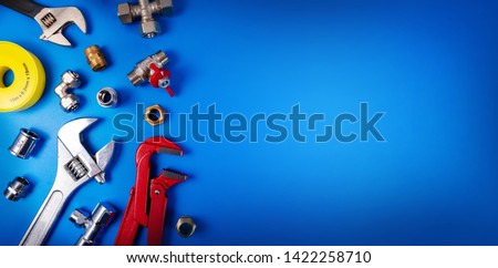 plumbing tools and fittings on blue background with copy space